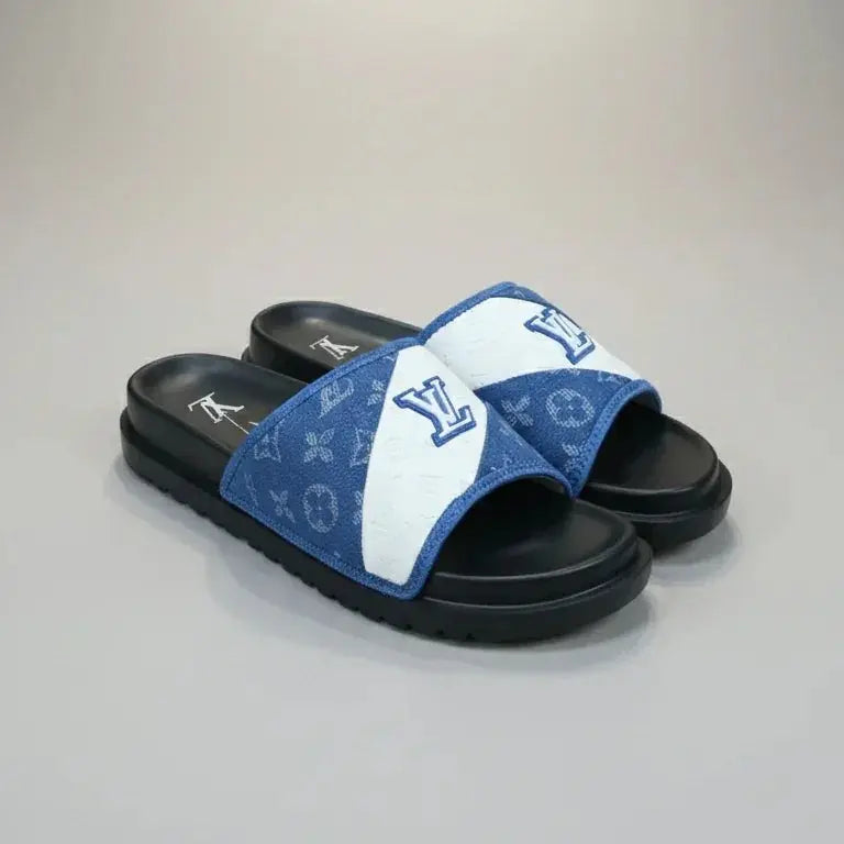 Blue and white slide sandals with a brand logo on a gray background