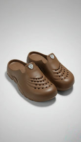 Pair of brown clogs on a light gray background