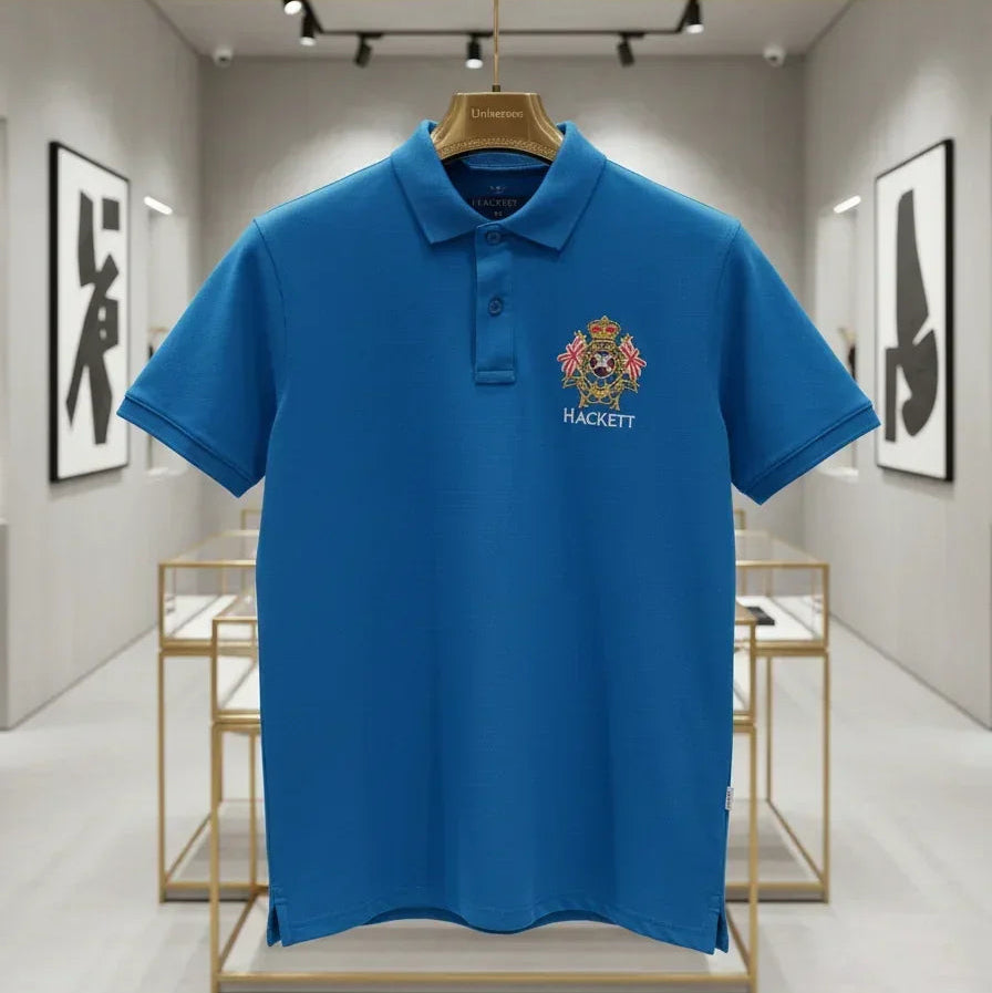 Blue polo shirt with a logo on a hanger in a modern interior setting
