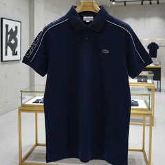 Navy blue polo shirt with brand logo on a hanger in a store setting