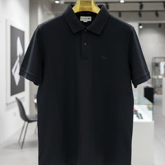 Black polo shirt hanging on a rack in a store setting