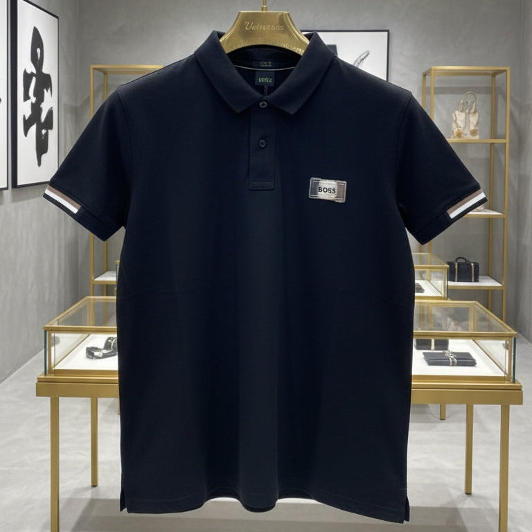 Navy blue polo shirt with a brand logo on a hanger in a store setting.