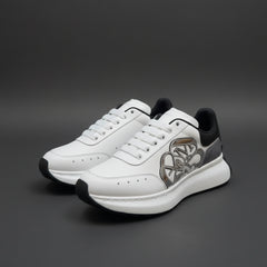 A pair of white Alexander McQueen Sprint Runner sneakers with a silver Seal logo and black heel tab, displayed on top of the official white shoe box.