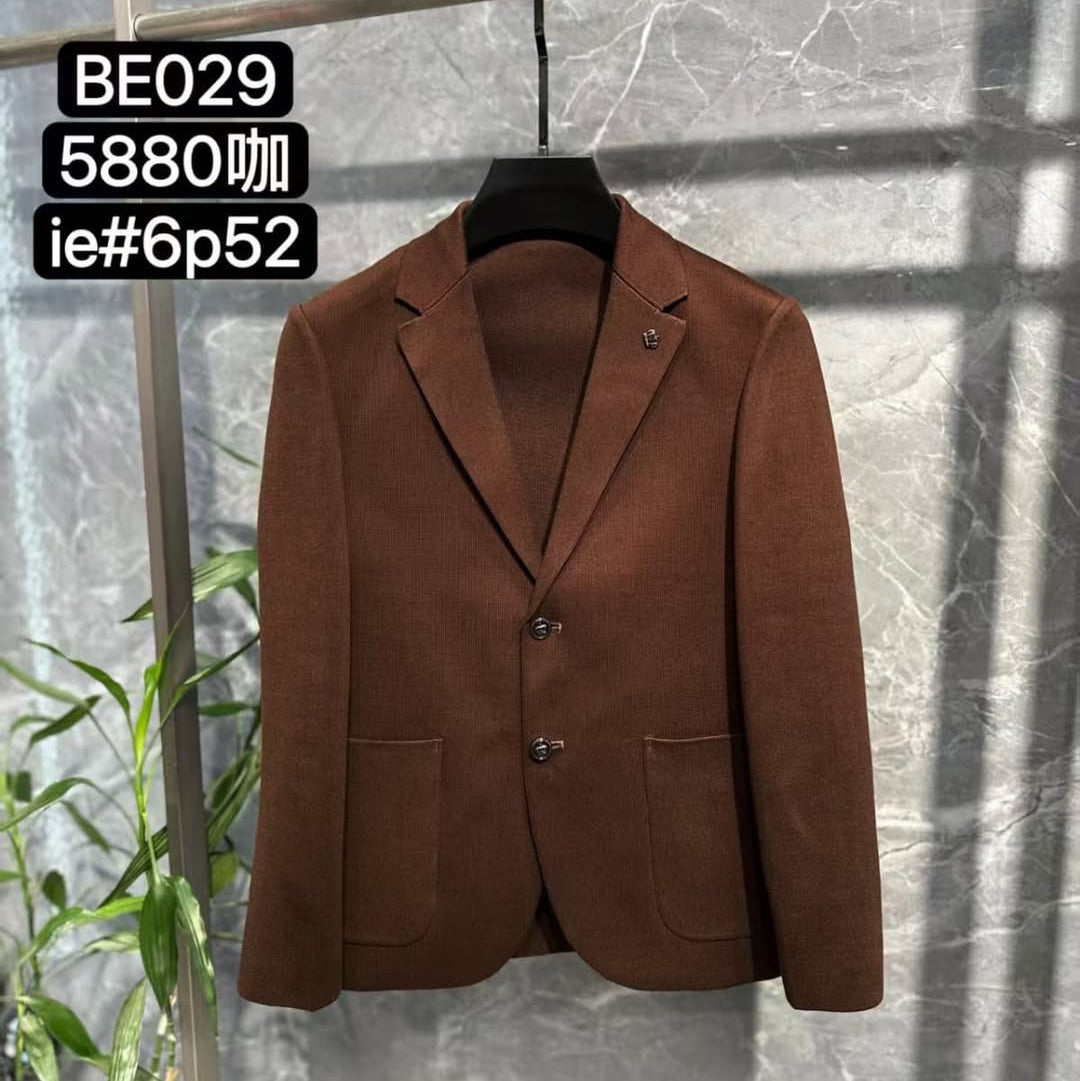Brown blazer on a hanger against a gray marble wall