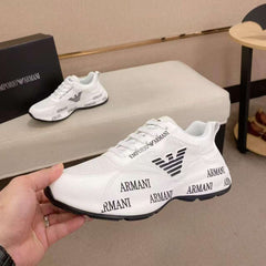 White Armani sneakers with black logo and text on a neutral background