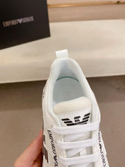 White sneaker with brand logo held by a hand, blurred background