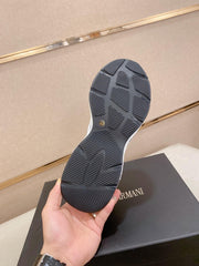 Black sole of a shoe held by a hand with Armani box in the background