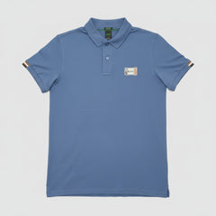 Blue polo shirt with a brand logo on a brown leather couch.