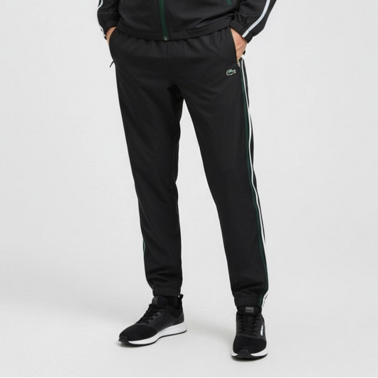 Person wearing black tracksuit with white stripes on a light gray background