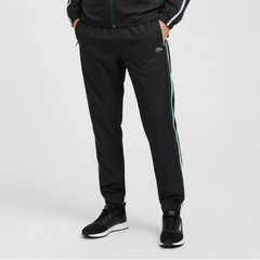 Person wearing black tracksuit with white stripes on a light gray background