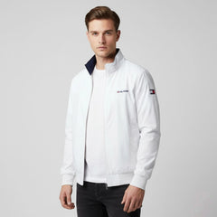 Man wearing a white jacket with a brand logo on a gray background
