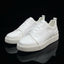 White sneakers with a brand logo on a white box against a brick wall background