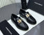 Black loafers with gold buckles on a Dolce & Gabbana branded box.