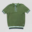 Green polo shirt with white and black trim on a light gray background