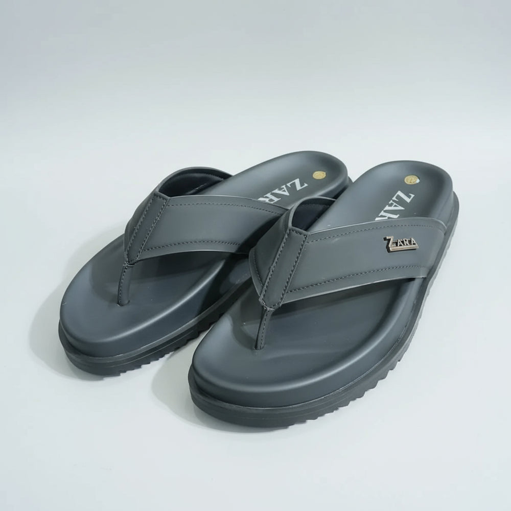 Gray sandals with 'Zara' branding on a wooden surface.