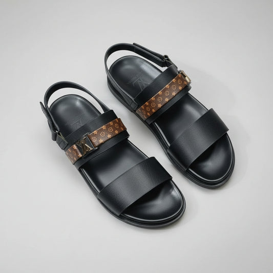 Black sandals with brown strap on a wooden surface