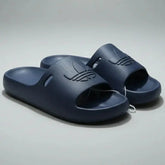 Pair of navy blue slides on a gray background