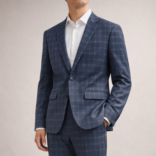 Man wearing a blue checkered suit with a white shirt on a plain background