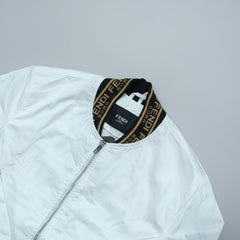 White jacket with Fendi logo on a wooden surface