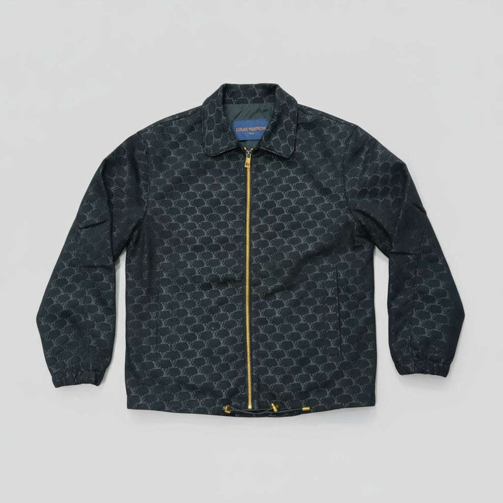 Dark patterned jacket with a gold zipper on a light gray background