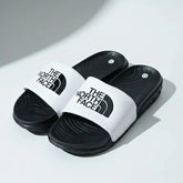 Black and white slides with The North Face logo on a light gray background