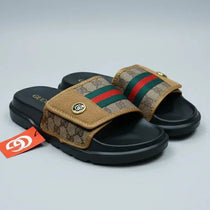 Pair of Gucci slides with a brand tag on a gray background