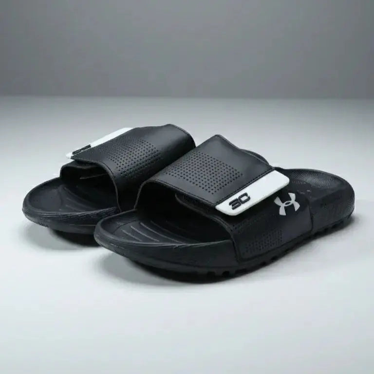 Black slide sandals with a brand logo on a gray background মূল ছবি
