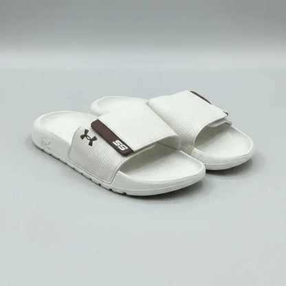 White sandals with a brown logo on a gray background