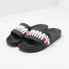 Black slides with Tommy Hilfiger logo on a white background