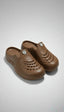 Pair of brown clogs on a light gray background