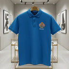 Blue polo shirt with a logo on a hanger in a modern interior setting
