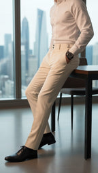 Person wearing a beige shirt and pants with black shoes in an office setting.