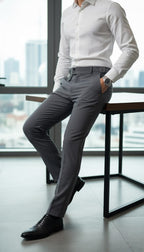 Man in white shirt and gray pants sitting on a chair with a cityscape background