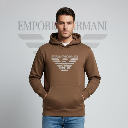 Man wearing a brown Emporio Armani hoodie on a gray background