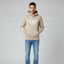 Man wearing a beige Emporio Armani hoodie and blue jeans on a gray background