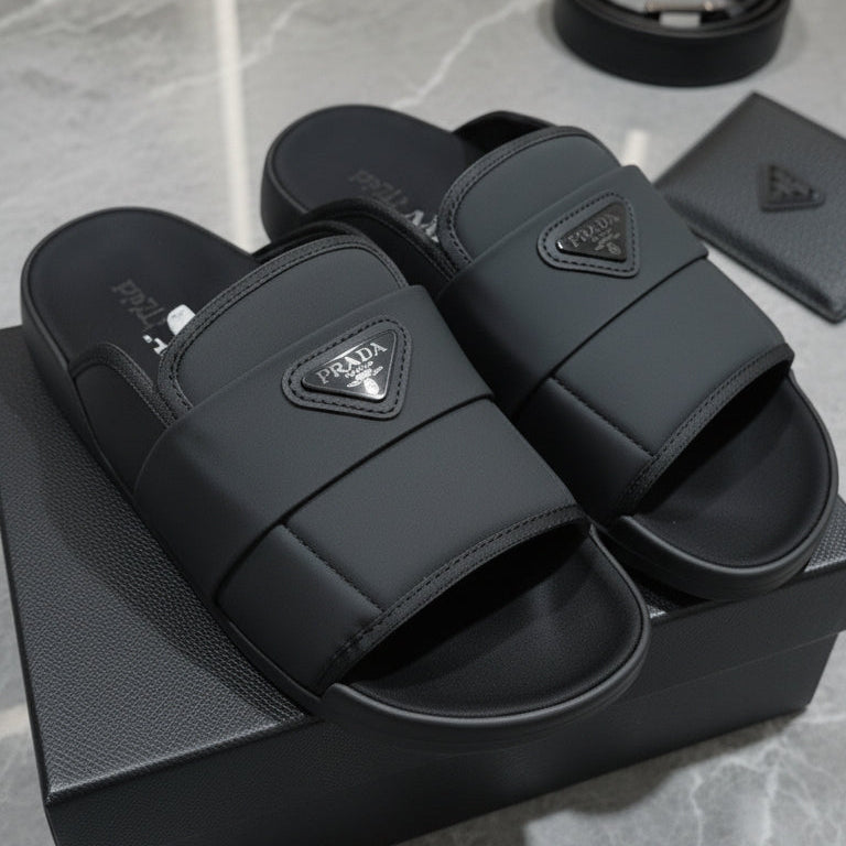 Black slides with Prada logo on a gray surface Main image