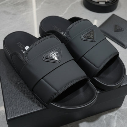 Black slides with Prada logo on a gray surface