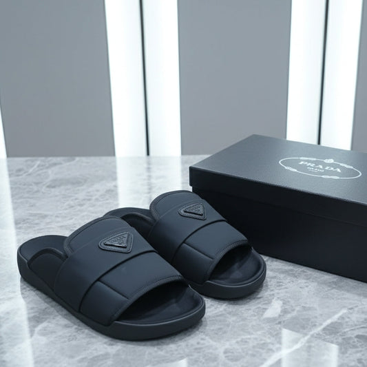 Black slides with a triangular logo on a marble surface next to their packaging box.
