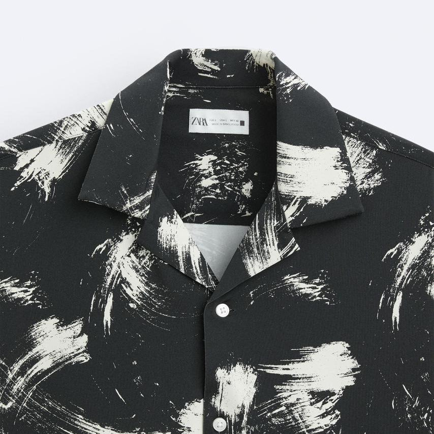 Black and white abstract patterned shirt with a brand label on a white background
