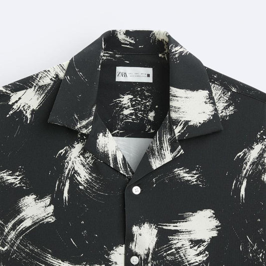 Black and white abstract patterned shirt with a brand label on a white background