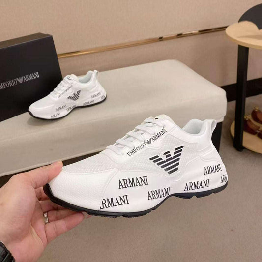 White Armani sneakers with black logo and text on a neutral background