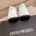 White high-top sneakers on a black Emporio Armani box with a beige background