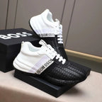 Black and white sneakers with woven pattern on a box labeled 'BOSS'.