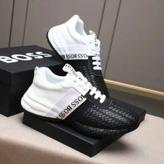 Black and white sneakers with woven pattern on a box labeled 'BOSS'.