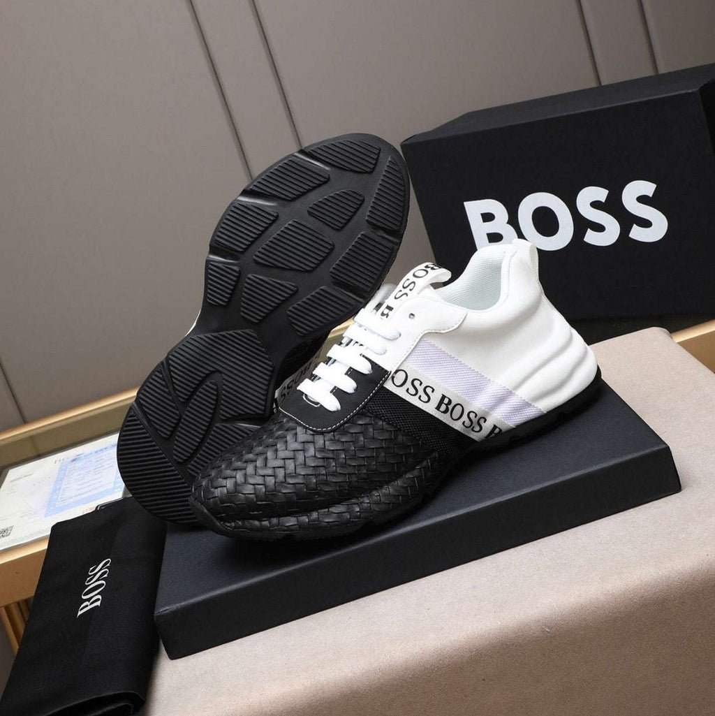 Black and white sneakers with 'BOSS' branding on a black box against a gray background.