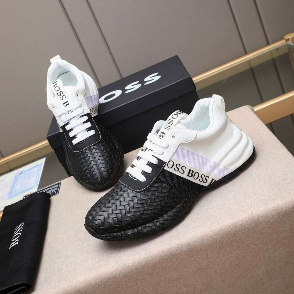 Black and white sneakers with 'BOSS' branding on a surface.