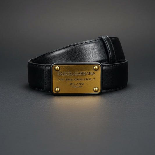 Black Dolce & Gabbana belt with gold plaque on a dark gray background