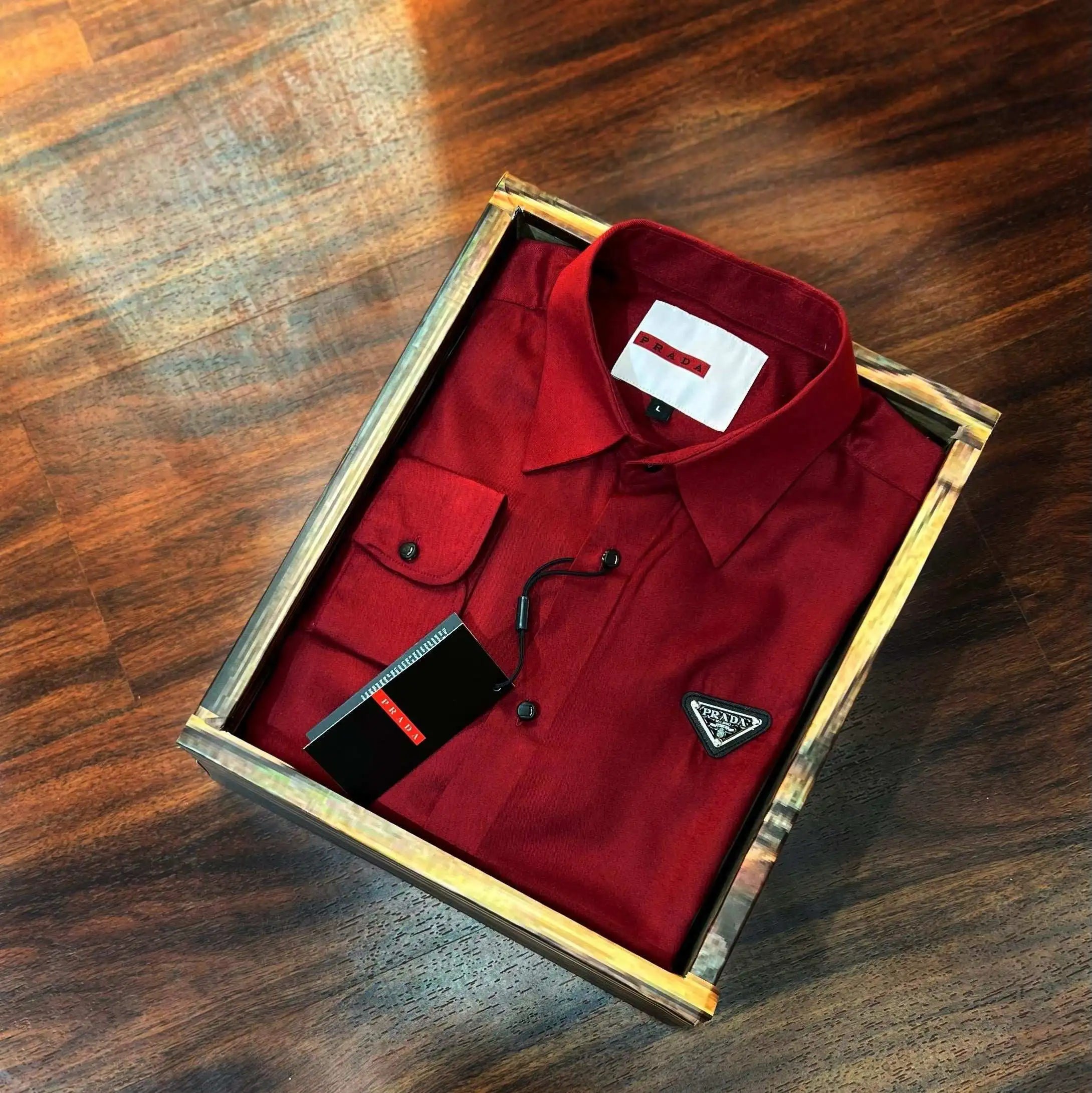 Red shirt with a logo in a wooden box on a wooden surface Main image