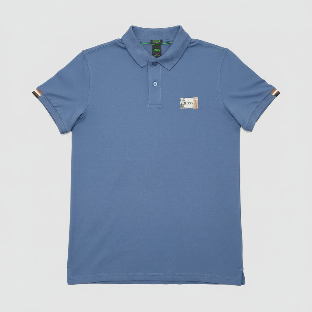 Blue polo shirt with a brand logo on a brown leather couch.