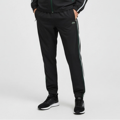 Person wearing black tracksuit with white stripes on a light gray background